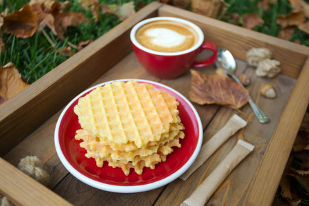 breakfast - waffles and cup of coffee on a wooden tray