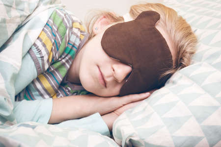 little girl sleeping in sleep mask. sleep and healthの写真素材