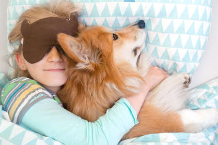 dog corgi little girl sleeping in sleep mask. child and dogの写真素材
