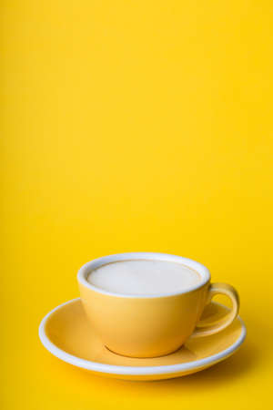 beautiful coffee yellow cup with  cappuccino on yellow backgroundの写真素材