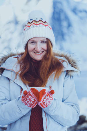 winter. girl with a cup on the background of rorbu on the Lofoten islands. Norwayの写真素材