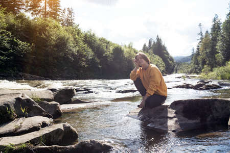girl hiker on the bank of a mountain riverの写真素材
