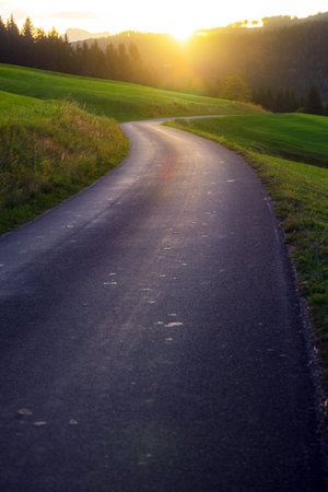 Mountain road - road in the mountains of austria at sunrise