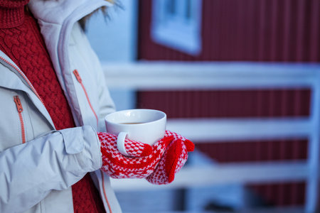 girl with a cup on the background of rorbu on the Lofoten islands. Norwayの写真素材