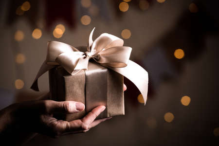 girl holding beautiful  gift for the day valentines day. box and bow and bokeh in the backgroundの写真素材