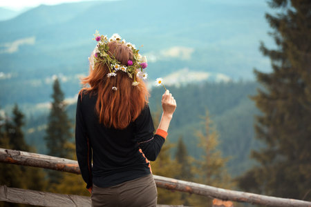 girl in a wreath of wildflowers in the mountains.