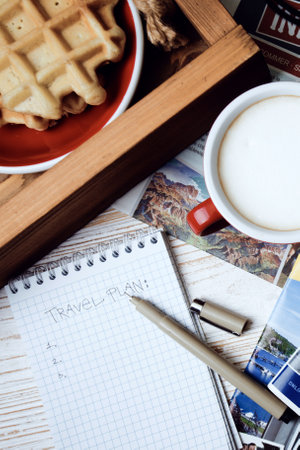 DNIPRO, UKRAINE - DECEMBER 1, 2019: Plan of trip. background - travel preparation. notepad for writing ideas, camera, coffee, pen, sunglasses, smartphone, headphones and advertising magazinesのeditorial素材