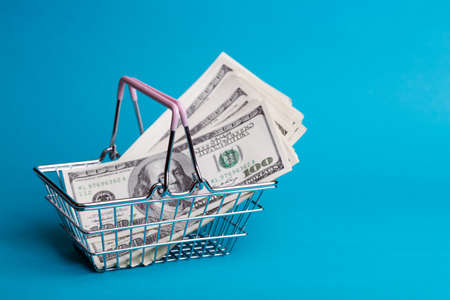 Prices for shopping consumer basket products. empty basket on a blue background full of dollars
の写真素材