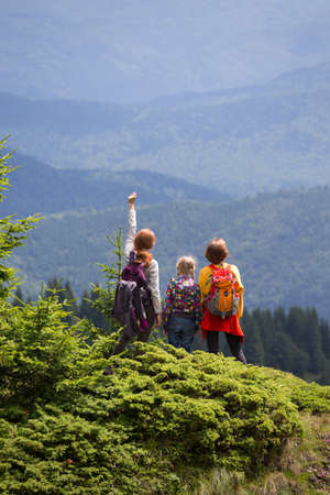 happy family in the mountains. mother with daughters are walking in the mountainsの写真素材