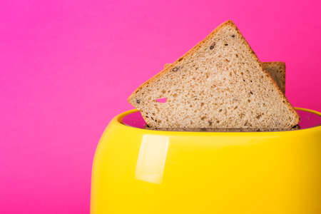 bright, fun breakfast. yellow toaster on a pink backgroundの写真素材