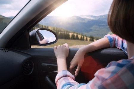 Summer Road Trip. Happy beautiful girl traveling in a car across  at the mountains. Romania