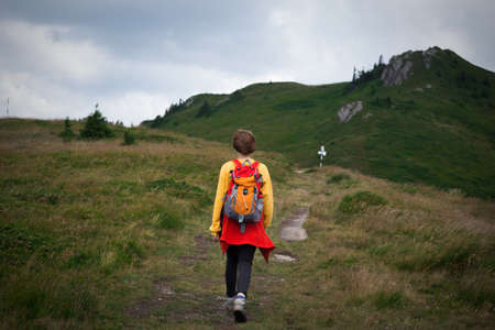 tourist girl is going on the trail in the mountains  
の写真素材