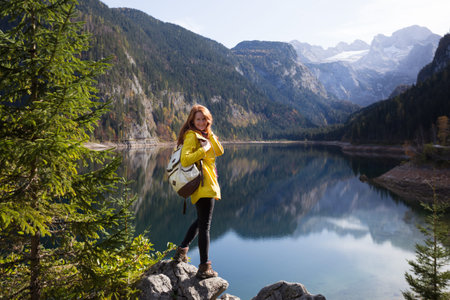 mountain trip. happy girl on the background of a mountain lake and mountains in the background