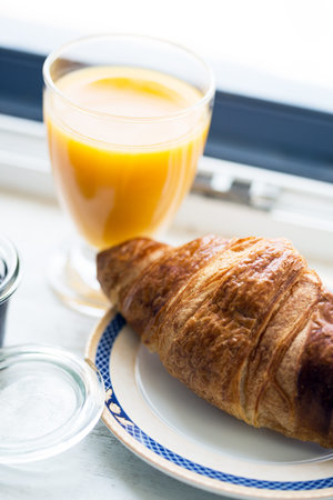 delicious French breakfast - croissant, jam and orange juice
