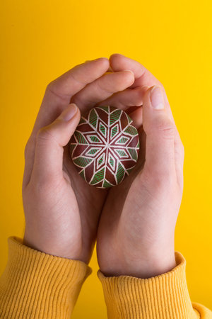 happy easter card. girl holds in hands beautiful Easter egg Pysanka handmade - ukrainian traditional...