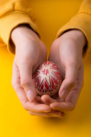 happy easter card. girl holds in hands beautiful Easter egg Pysanka handmade - ukrainian traditional 
の写真素材