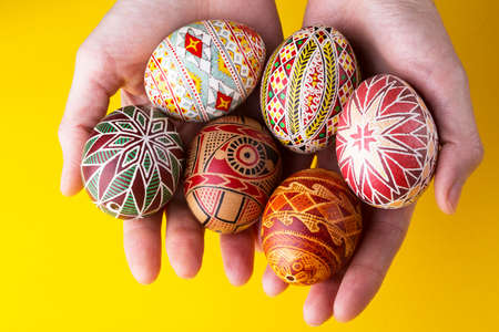 happy easter card. girl holds in hands beautiful Easter egg Pysanka handmade - ukrainian traditionalの写真素材