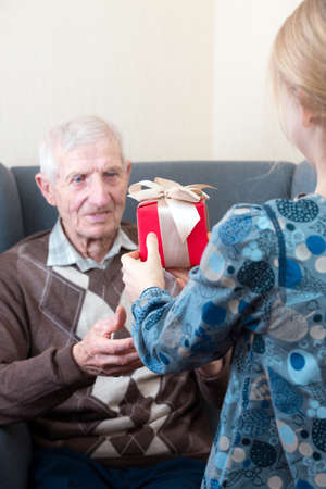 portrait of  senior man.  granddaughter gives grandfather a gift. leisure old manの写真素材