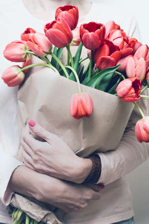 girl holding a huge bouquet of red tulips in their hands. bright springの写真素材