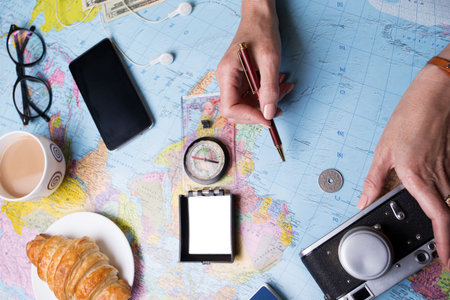 Plan of trip. background - what to take for a trip. Women hands and map, retro camera, money, coins,...