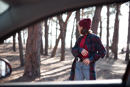 beautiful stylish girl holding a camera in the forest at sunset timeの写真素材