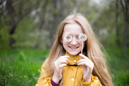 blonde Little girl holding dandelion. spring holidays and mood