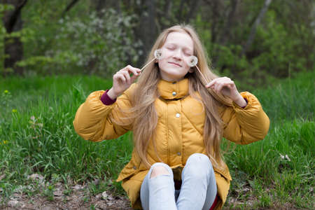 blonde Little girl holding dandelion. spring holidays and moodの写真素材