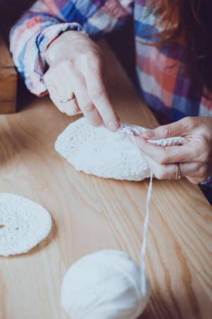 girl crocheting a rug. Woman knits crochet. Home comfort and hobby. Needleworkの写真素材