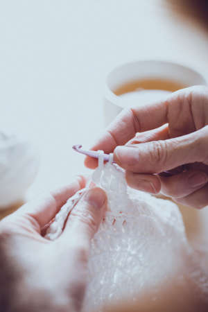 girl crocheting a rug. Woman knits crochet. Home comfort. Needleworkの写真素材