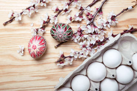 happy easter card. Box with   beautiful Easter eggs Pysanka handmade and sprigs of blossoming apricot on a wooden background  
の写真素材
