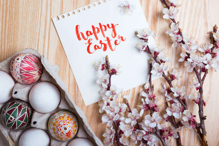 happy easter card. Box with   beautiful Easter eggs Pysanka handmade and sprigs of blossoming apricot on a wooden background  の写真素材