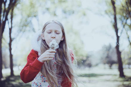 blonde Little girl holding dandelion. spring holidays and moodの写真素材