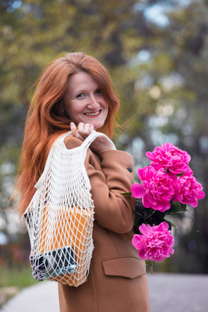 summer - happy beautiful girl with bouquet of peonies