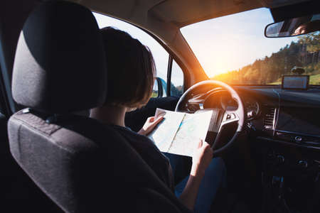 girl sitting in the car and looking mapの写真素材