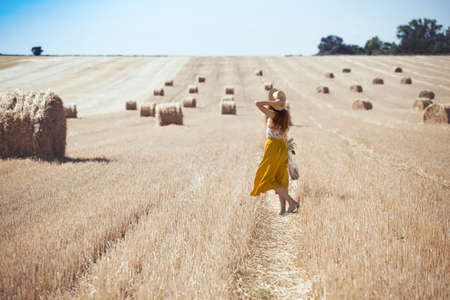 beautiful landscape - round bales and a girl in the fieldの写真素材