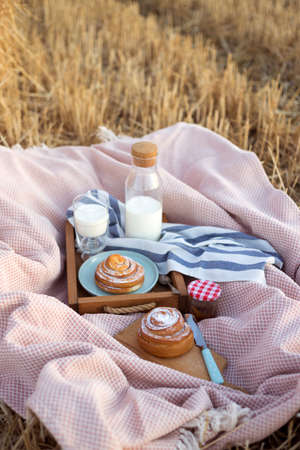 picnic in a wheat field near Round Bales. milk and cinnamon rollsの写真素材