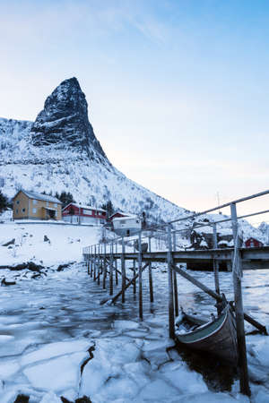 traditional norwegian wooden house to stand on the shore of the fjord and mountains in the distance. Lofoten Islands. Norway. world travelの写真素材