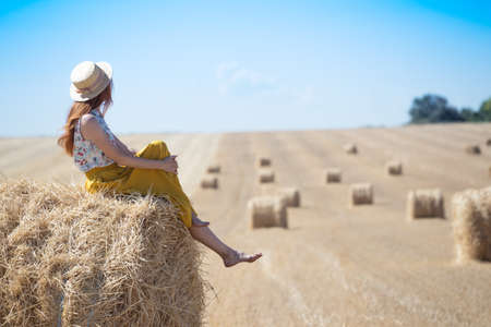 beautiful landscape - round bales and a girl in the fieldの写真素材