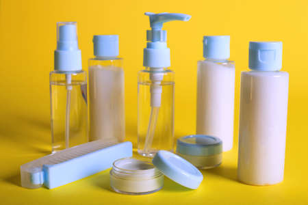 travel beauty kit on a yellow background. shampoo, balm, cream and lotion in vialsの写真素材