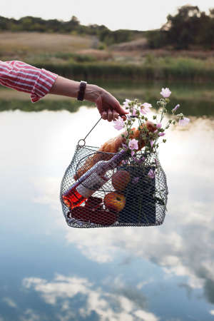 Summer still life - picnic basket on the background of the riverの写真素材