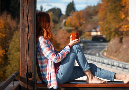 Girl with a cup of coffee. picture taken through window glass. morning at dawn