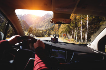 roadtrip - man hands on the wheel and mountains.  Alps, Austria