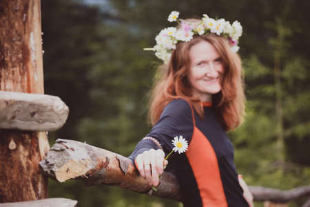 girl in a wreath of wildflowers in the mountainsの写真素材