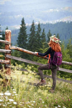 girl in a wreath of wildflowers in the mountainsの写真素材