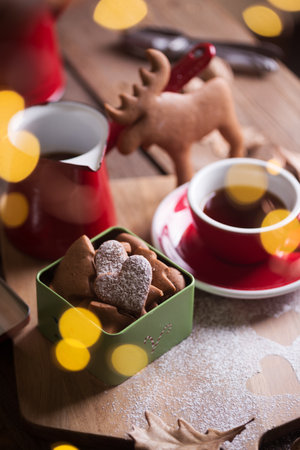 christmas still life. gingerbread in a box on the background of a cup, teapot and bokehの写真素材