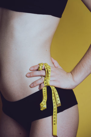 girl measures her volumes with a centimeter. healthy and beautiful body. Female body, slim waist.