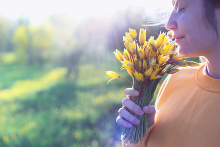 spring mood and feeling of freedom. girl holding a bouquet of yellow wild tulipsの写真素材
