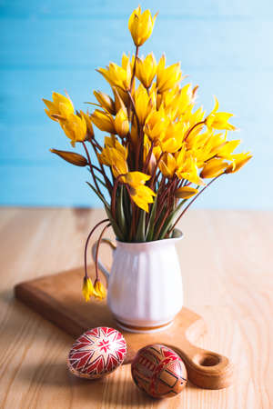 happy easter card. still life - beautiful Easter egg Pysanka handmade and bouquet of wild tulips with inscription happy easterの写真素材