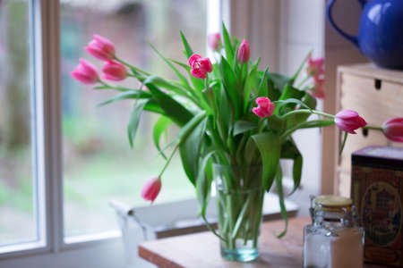 beautiful pink tulips in a vase in the vintage kitchen. still lifeの写真素材