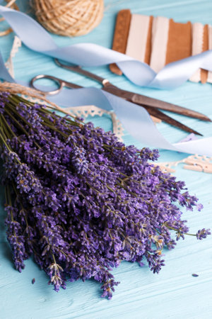 still life. creating a bouquet. lavender, ribbons, scissors on a blue backgroundの写真素材